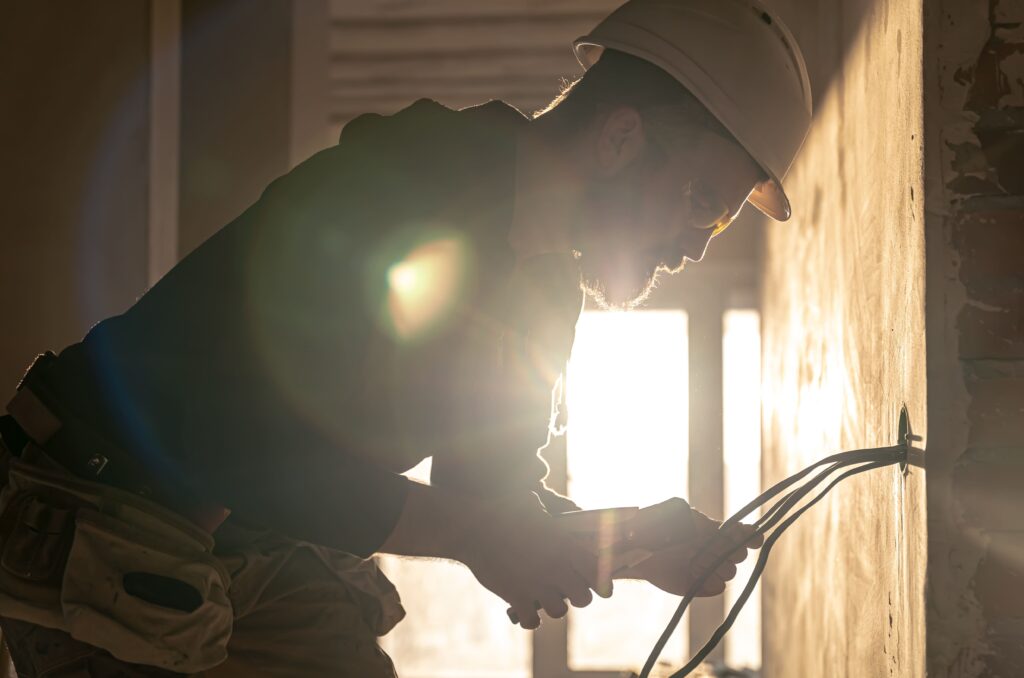 worker is cutting wires with linemans pliers